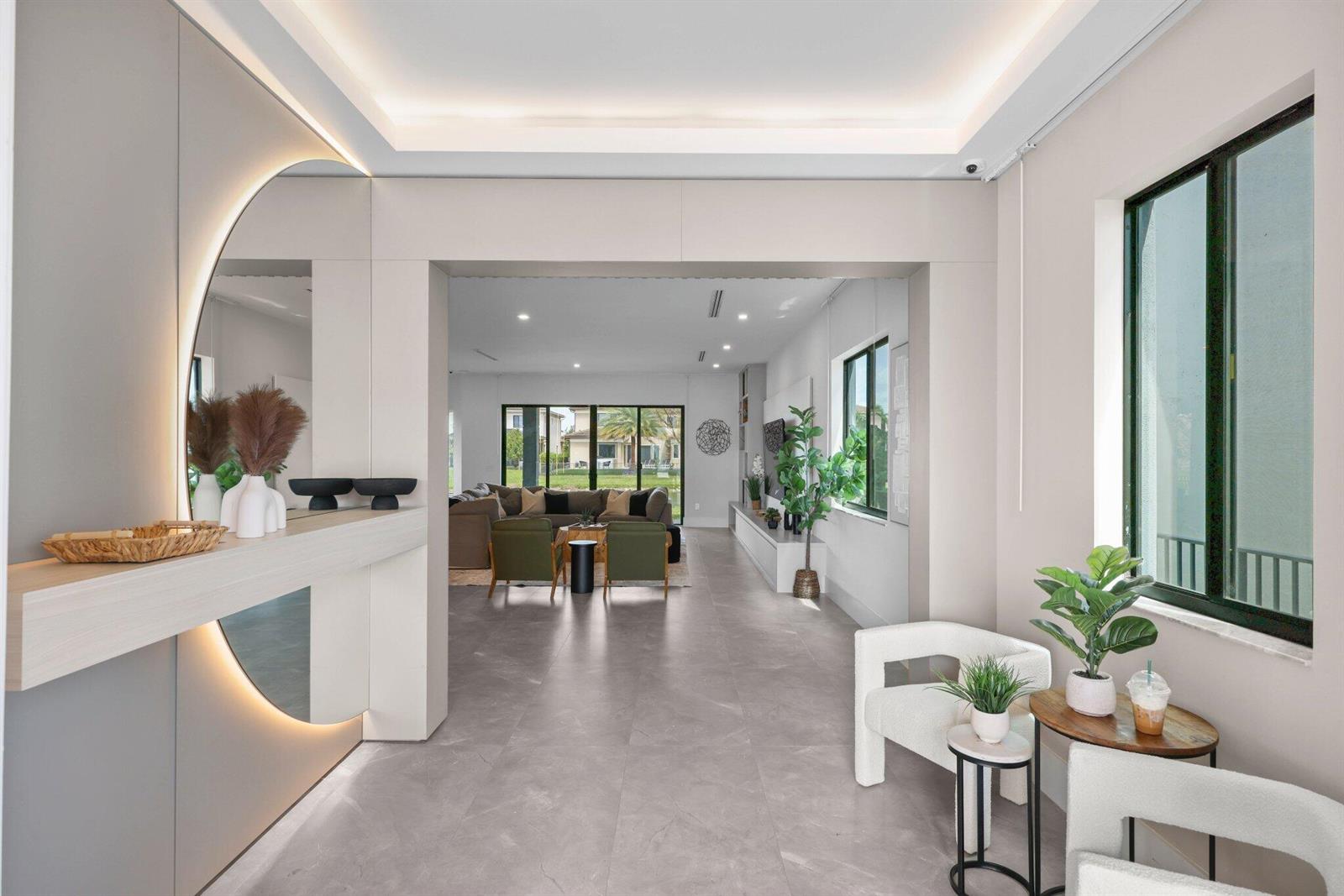 A modern entryway leads into a living room with gray tile floors and recessed lighting — 10725 Passage Way, Parkland FL 33076, PARKLAND, FL