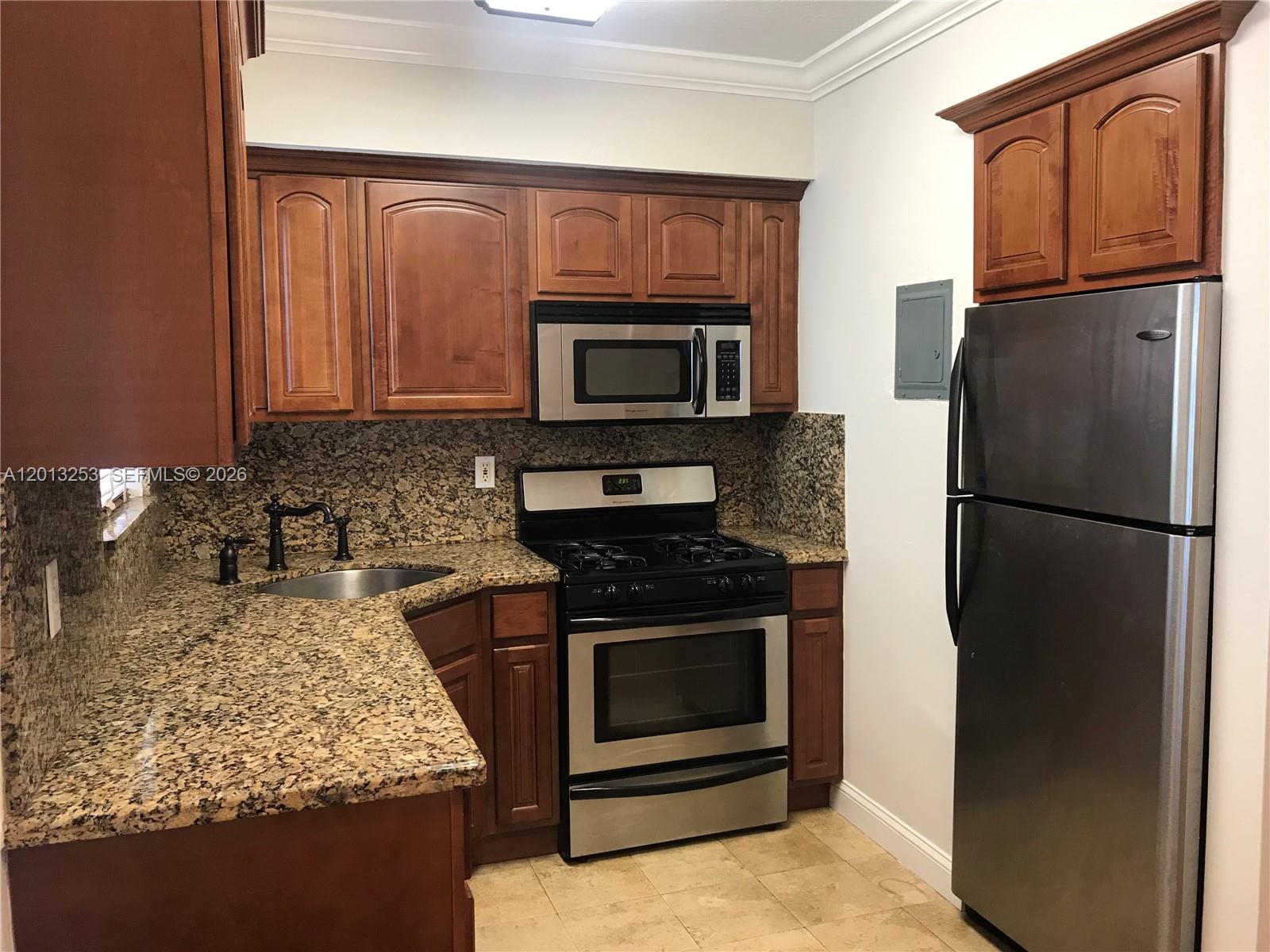 A kitchen features wood cabinets, granite countertops, stainless steel appliances, and a corner sink — 35 Antilla Ave # 2, Coral Gables FL 33134, CORAL GABLES, FL