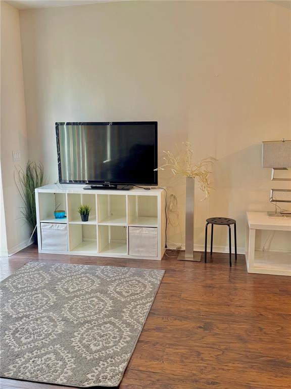 A living room features a television on a white shelving unit, a rug, and flooring — 1150 S BEACH CIRCLE, KISSIMMEE, FL