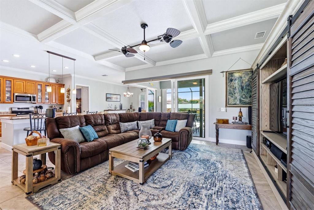 A living room with a brown sectional sofa, coffered ceiling, and a large area rug — 15610 SEAFOAM CIRCLE, PORT CHARLOTTE, FL