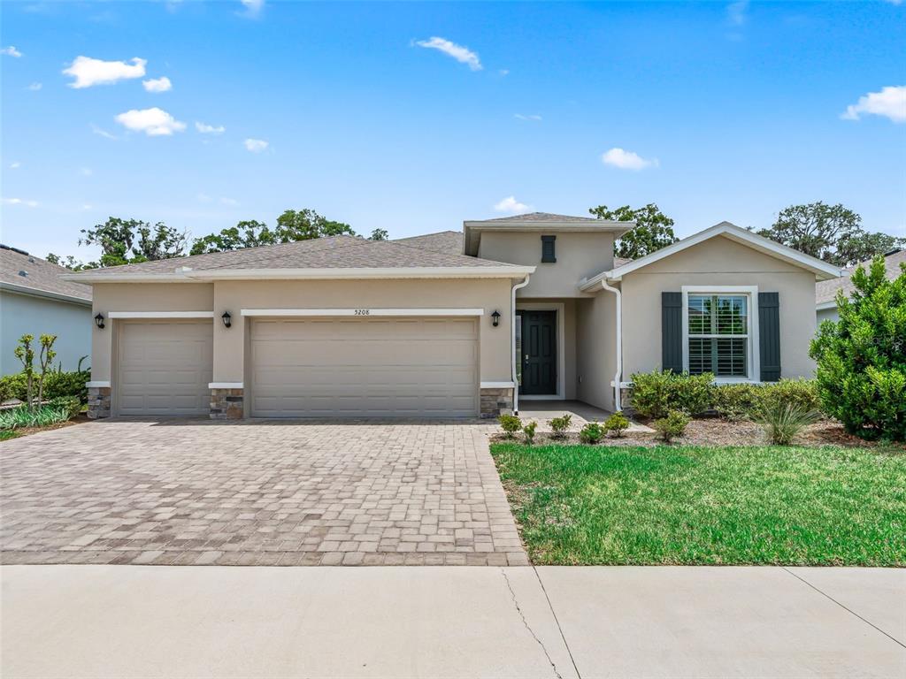 A single-story house features a three-car garage, a paved driveway, and a front entrance — 5208 NW 46TH LANE ROAD, OCALA, FL