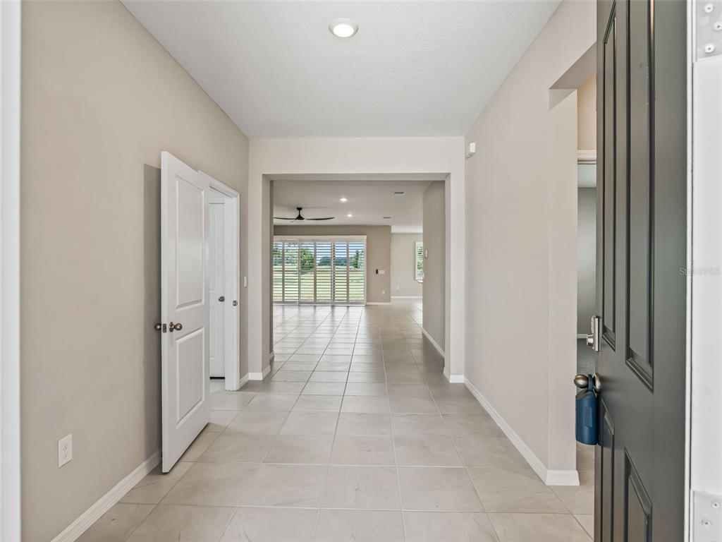 A view from an open front door into a tiled entryway leading to a living area — 5208 NW 46TH LANE ROAD, OCALA, FL