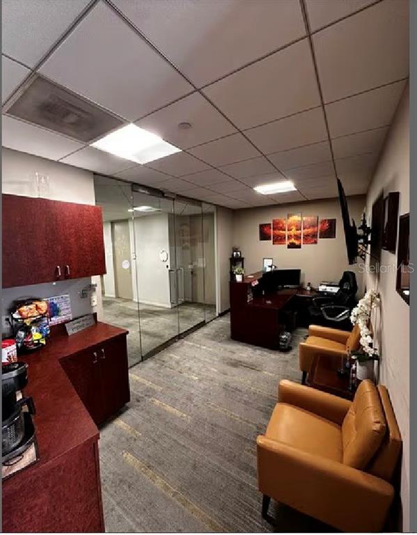 An office reception area features a coffee station, two leather chairs, and a glass-walled office — 400 N ASHLEY DRIVE UNIT 2050, TAMPA, FL