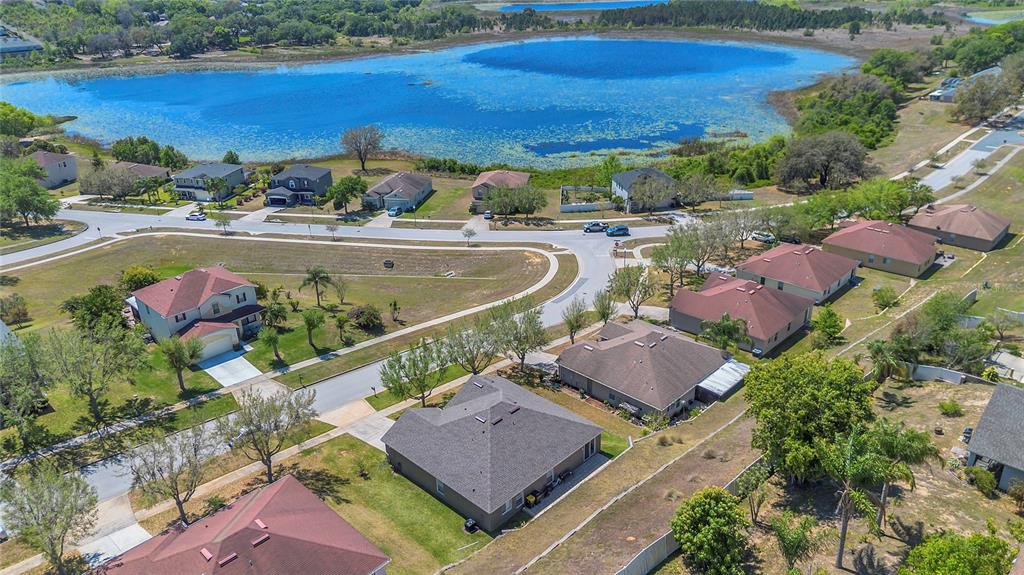 An aerial view shows a suburban neighborhood with single-family homes situated near a large lake — 1510 PIER STREET, CLERMONT, FL