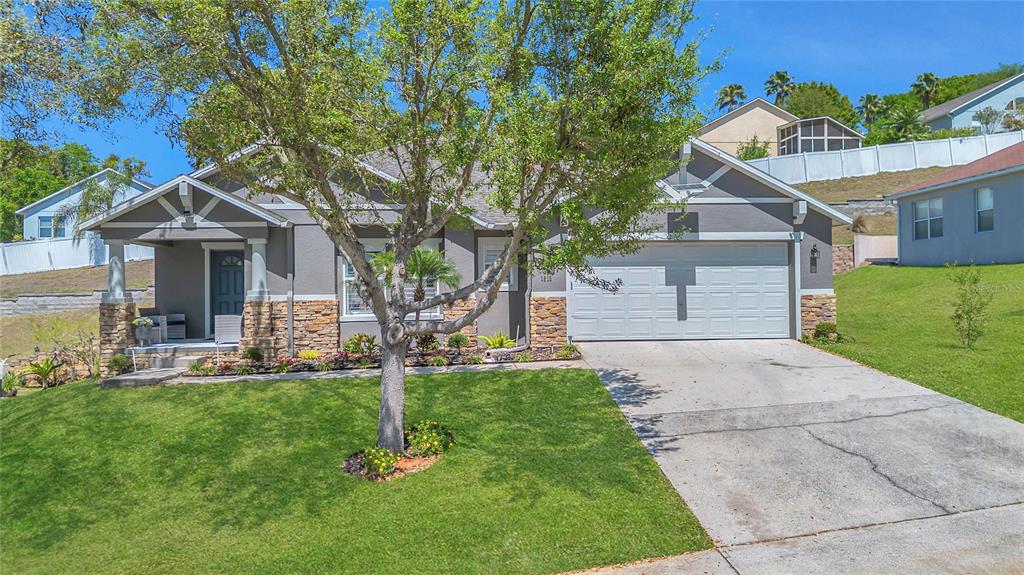 A single-story house with a stone facade, a two-car garage, and a front porch — 1510 PIER STREET, CLERMONT, FL
