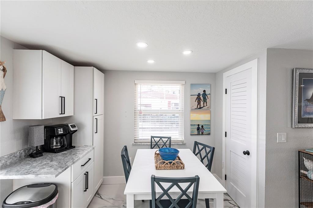 A kitchen dining area features white cabinets, a marble-patterned countertop, and a white table — 6154 MIDNIGHT PASS ROAD UNIT C16, SARASOTA, FL