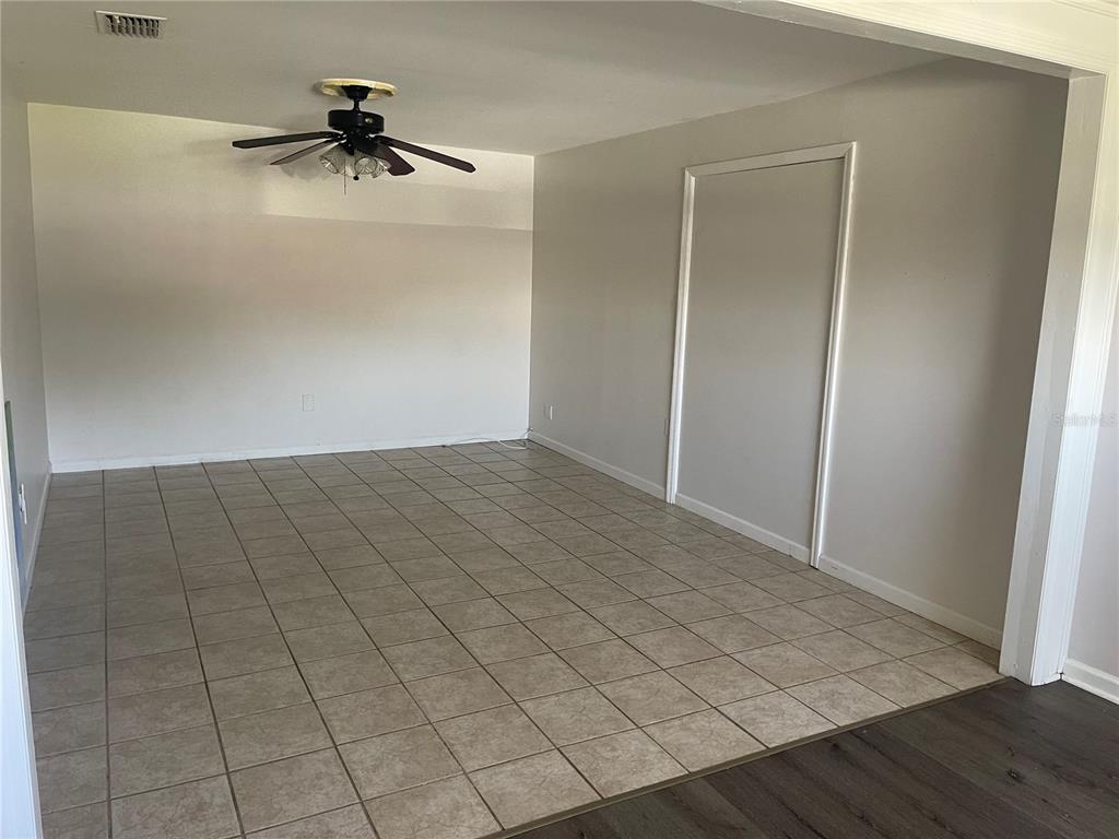 An interior view shows a room with tiled and wood-look flooring and a hanging chandelier — 3101 W DEWEY STREET, TAMPA, FL