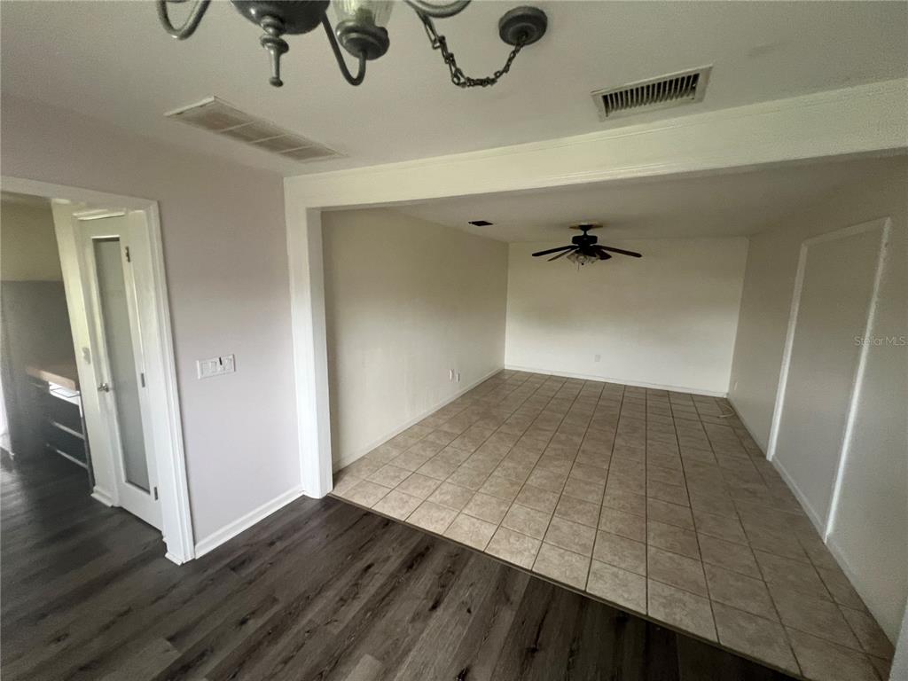 A view from a room with wood-look flooring looking into a kitchen with light cabinets — 3101 W DEWEY STREET, TAMPA, FL