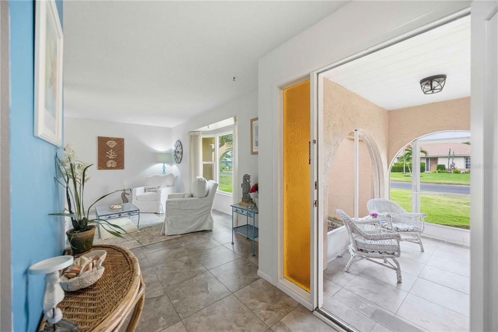 A view from an entryway into a living room and an adjacent enclosed outdoor patio — 119 VAN DYCK DRIVE, NOKOMIS, FL