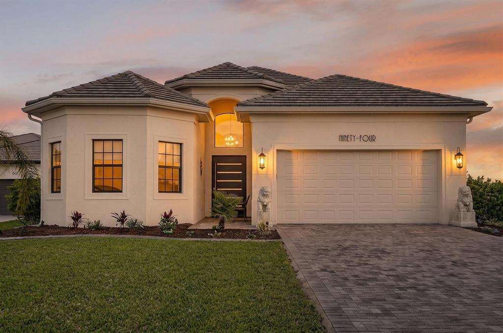A single-story stucco house with a tiled roof, two-car garage, and a paved driveway — 94 DEL PALMA DRIVE, PALM COAST, FL