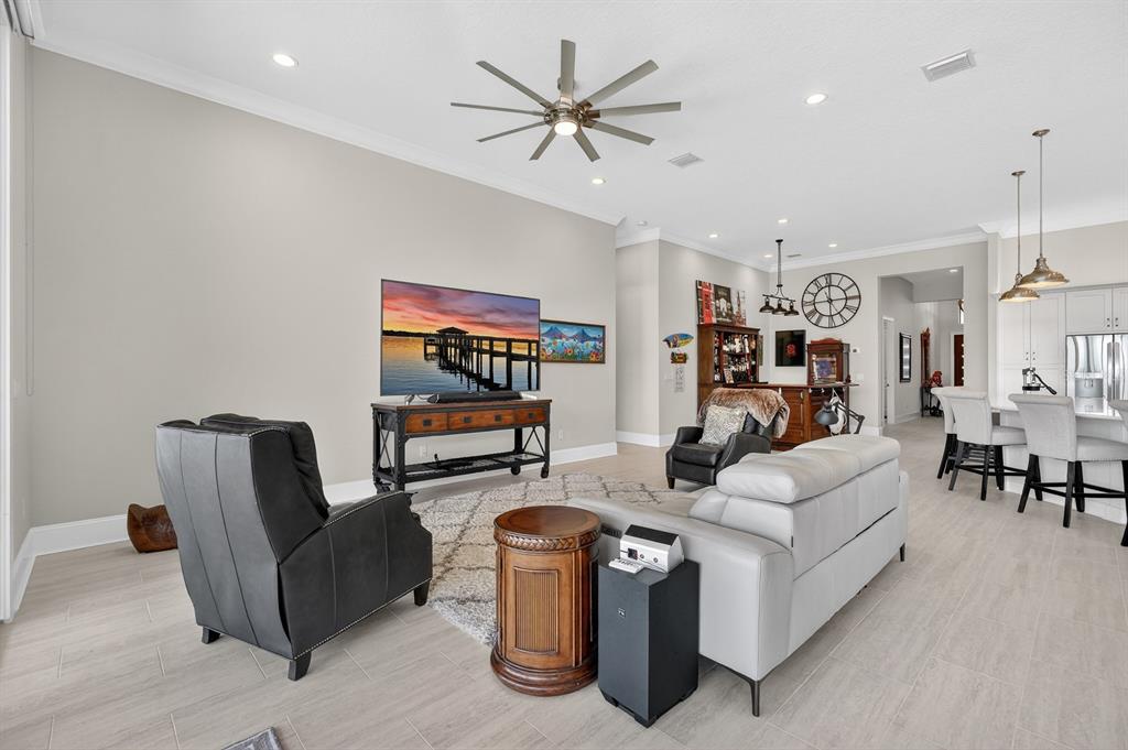 A living room features light tile flooring, a ceiling fan, and a television console — 94 DEL PALMA DRIVE, PALM COAST, FL