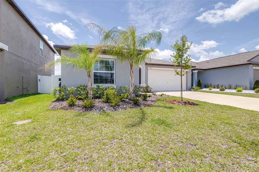 A single-story house with a gray exterior, a two-car garage, and two palm trees — 4312 FABULOUS FINCH LANE, BARTOW, FL
