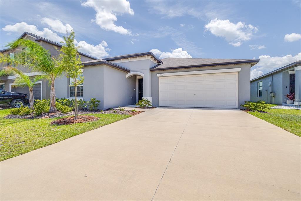 A single-story house with a gray exterior, a two-car garage, and a concrete driveway — 4312 FABULOUS FINCH LANE, BARTOW, FL