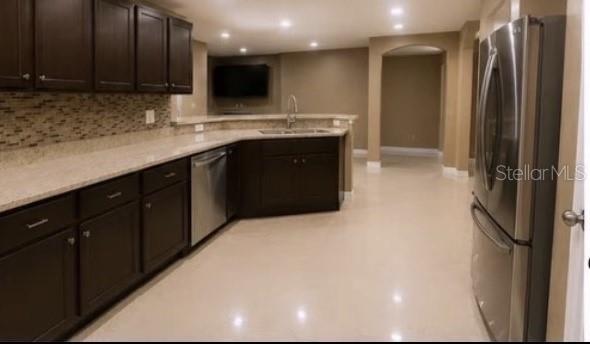 A kitchen features dark wood cabinets, granite countertops, stainless steel appliances, and light tile flooring — 171 SHADOWVIEW COURT, LEHIGH ACRES, FL