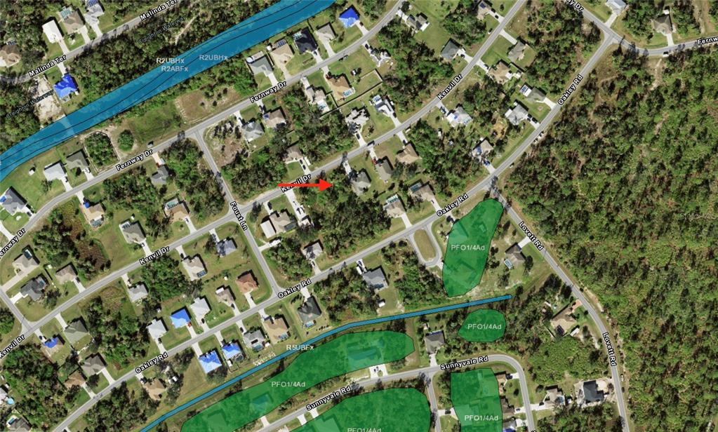 This is an aerial map showing residential streets, houses, and highlighted green wetland areas — KENVIL DRIVE, NORTH PORT, FL