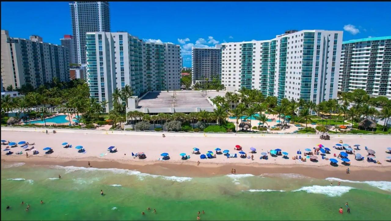 An aerial view of a beachfront condominium complex with a pool and sandy beach — 3901 S Ocean Dr # 1J, Hollywood FL 33019, HOLLYWOOD, FL