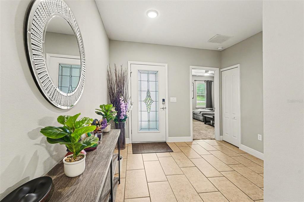 An entryway features a tiled floor, a console table with plants, and a front door — 15 LONE PINE STREET, HOMOSASSA, FL