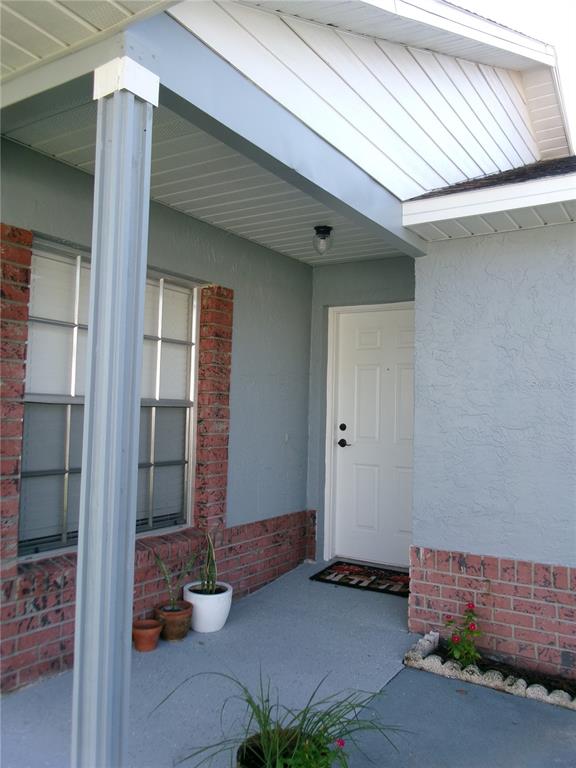 A detached brick garage with a white sectional door sits at the end of a driveway — 11700 MINTO COURT, ORLANDO, FL
