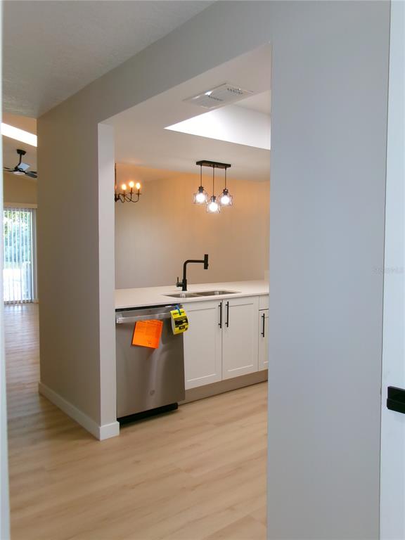 A garage with a gray epoxy floor, a water heater, and a screen door — 11700 MINTO COURT, ORLANDO, FL