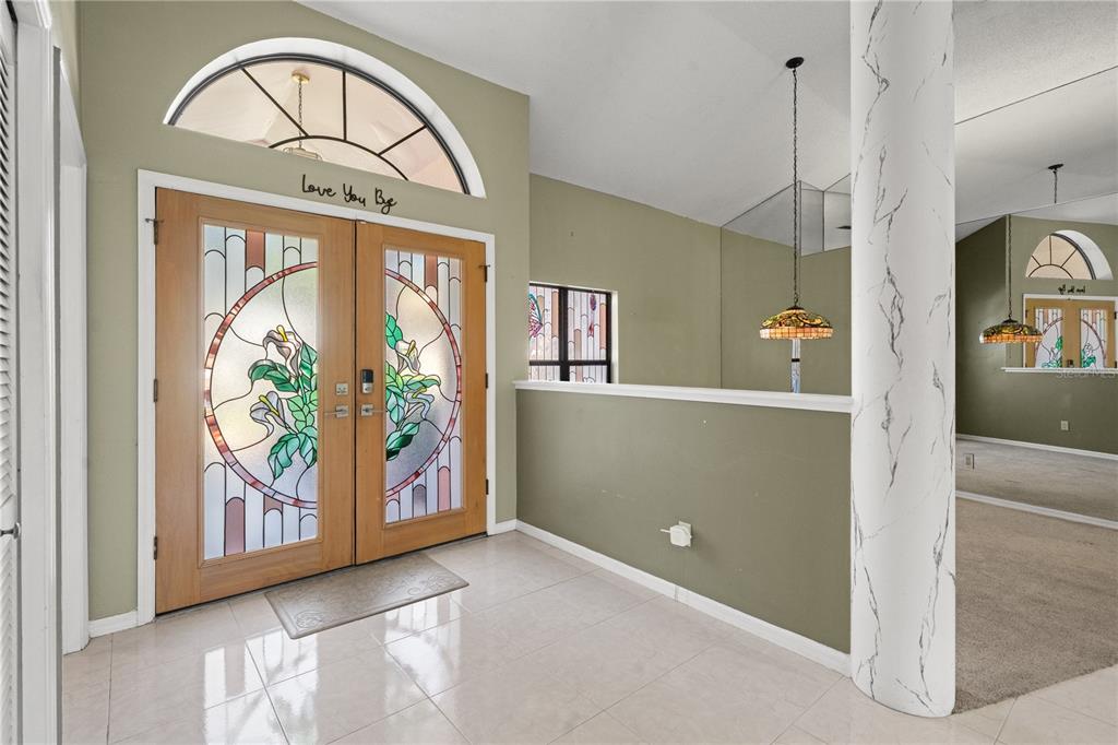 An entryway features double doors with stained glass, a tiled floor, and a decorative column — 15923 ELLSWORTH DRIVE, TAMPA, FL