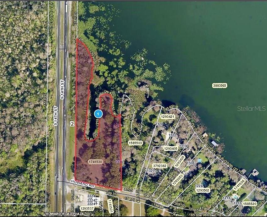 This is an aerial map showing property boundaries and parcel numbers for a wooded waterfront area — S US HWY 27 & HOWARD RD, LEESBURG, FL