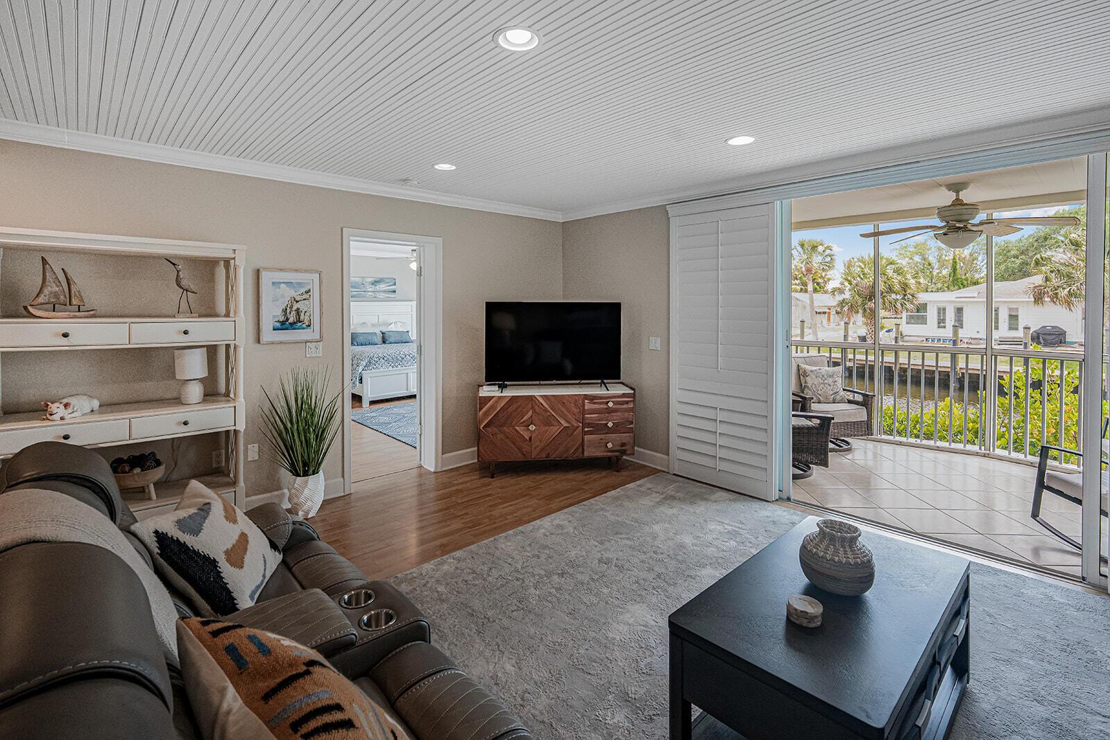 A screened-in porch features two rocking chairs, a small table, and a canal view — 3901 SE Saint Lucie Boulevard # 13, Stuart FL 34997, STUART, FL