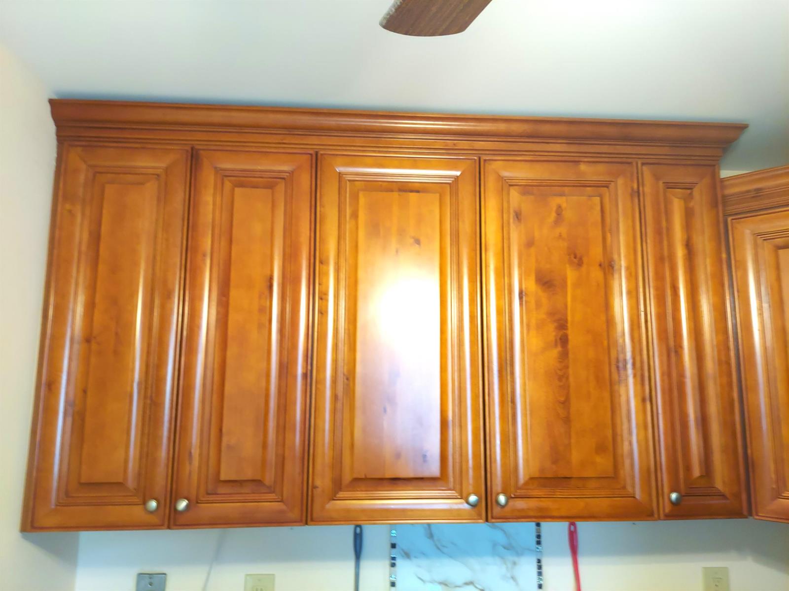 A row of wooden kitchen cabinets with raised panels and crown molding — 3020 Ashby D, Deerfield Beach FL 33442, DEERFIELD BEACH, FL