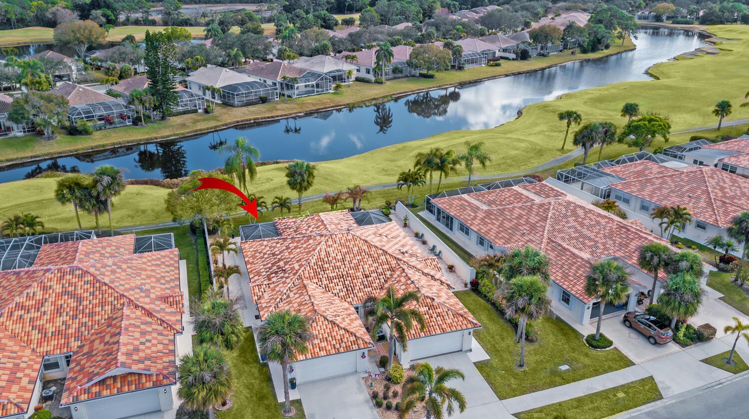 An aerial view of a residential neighborhood featuring houses with tiled roofs near a lake — 8285 SE Double Tree Drive, Hobe Sound FL 33455, HOBE SOUND, FL