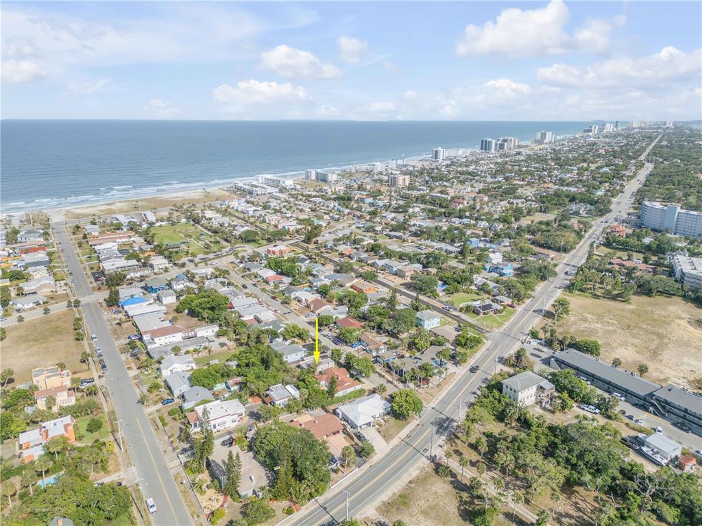 An aerial view shows a residential neighborhood near a beach with a yellow arrow pointing down — 315 SEARS AVENUE, DAYTONA BEACH, FL