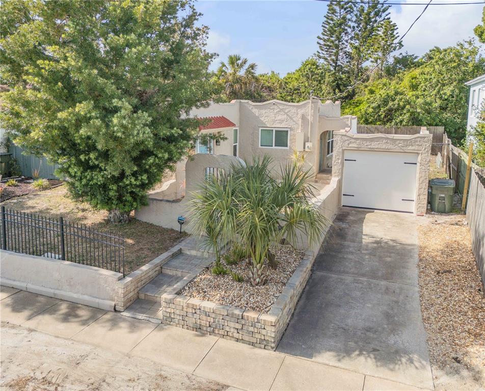 A single-story stucco house with a front courtyard, a palm tree, and an attached garage — 315 SEARS AVENUE, DAYTONA BEACH, FL