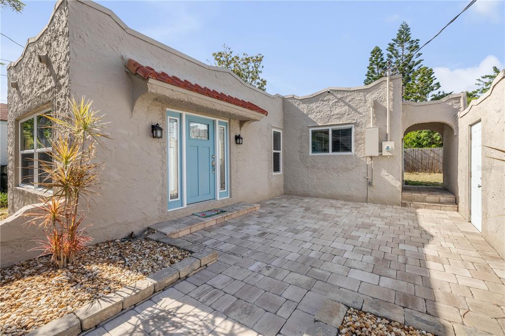 A stucco house with a blue front door and a paved patio entrance — 315 SEARS AVENUE, DAYTONA BEACH, FL