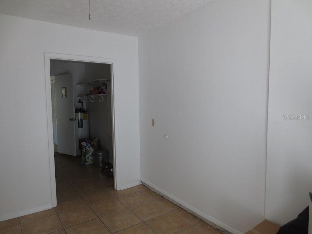 A room with white walls and tile flooring leads into a utility closet — 6713 S SHERIDAN ROAD, TAMPA, FL