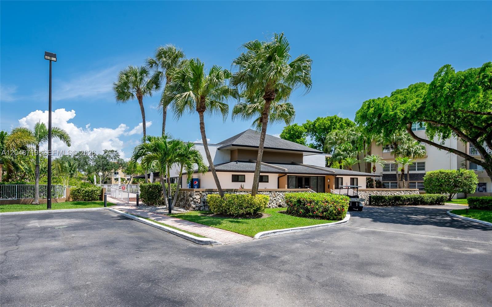A kitchen features white cabinets, stainless steel appliances, and light-colored tile flooring — 7705 SW 86th St # 114, Miami FL 33143, MIAMI, FL