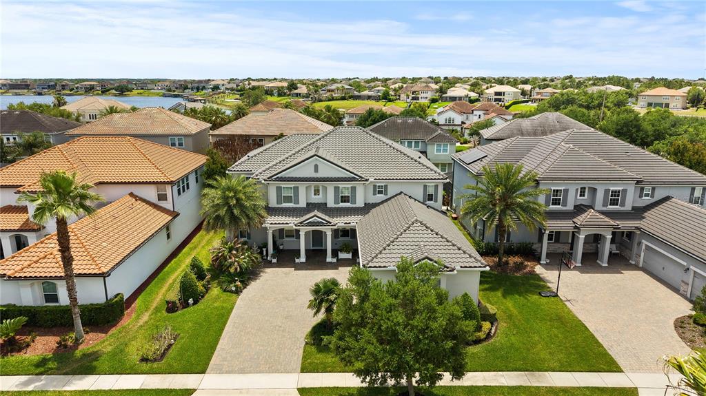 An aerial view shows a two-story house with a tiled roof and a paved driveway — 14240 COLONIAL POINTE DRIVE, WINTER GARDEN, FL