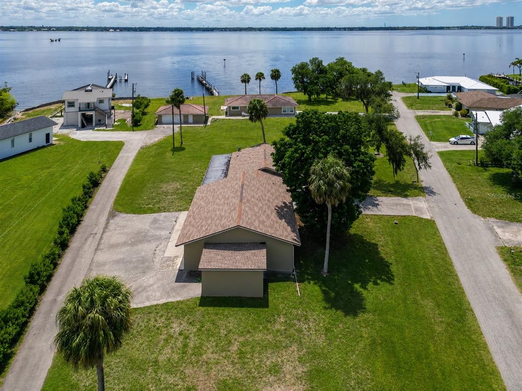 An aerial view shows a house with a brown roof near a large body of water — 1818/1822 STEVENSON ROAD, NORTH FORT MYERS, FL