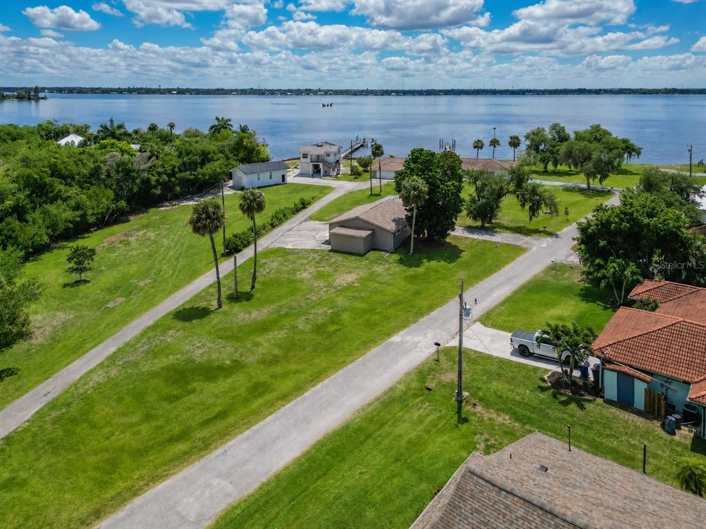An aerial view shows several houses on a grassy lot near a large body of water — 1818/1822 STEVENSON ROAD, NORTH FORT MYERS, FL