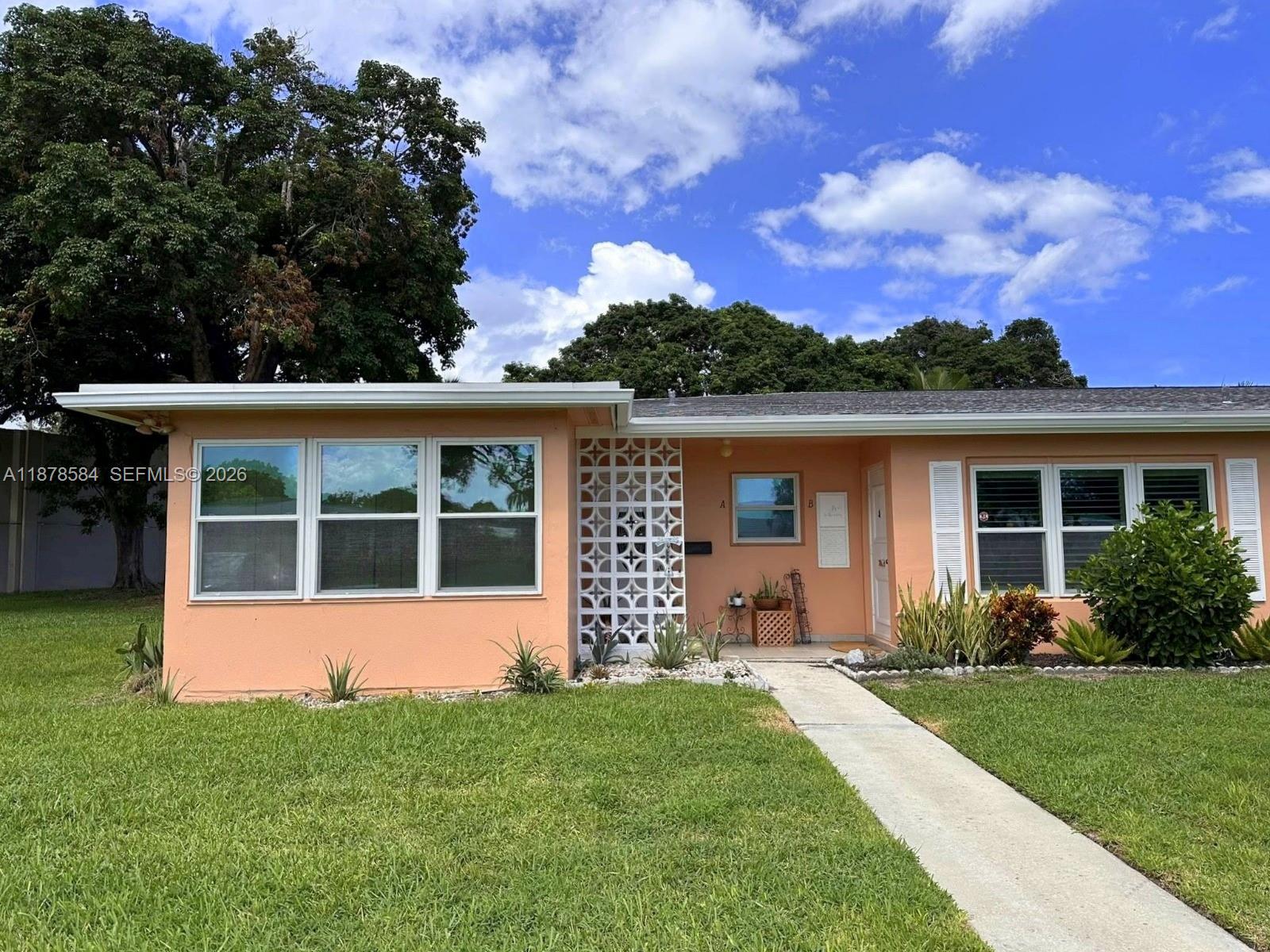 A peach-colored single-story house features a decorative concrete screen and a front walkway — 285 N High Point Blvd # A, Boynton Beach FL 33435, BOYNTON BEACH, FL