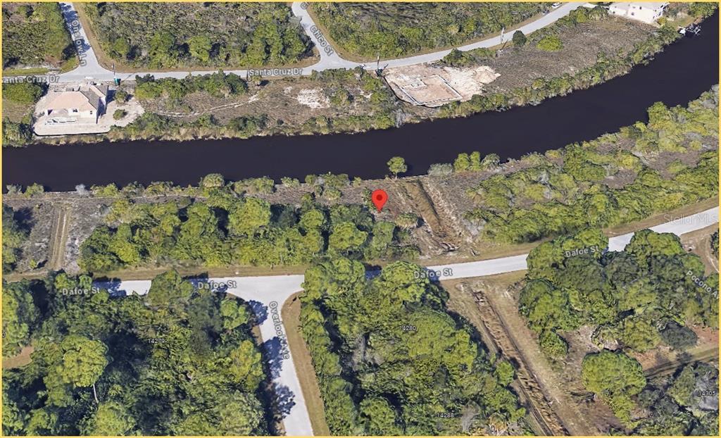 This aerial map shows a vacant, wooded lot situated between a canal and a road — 8301 DAFOE STREET, PORT CHARLOTTE, FL