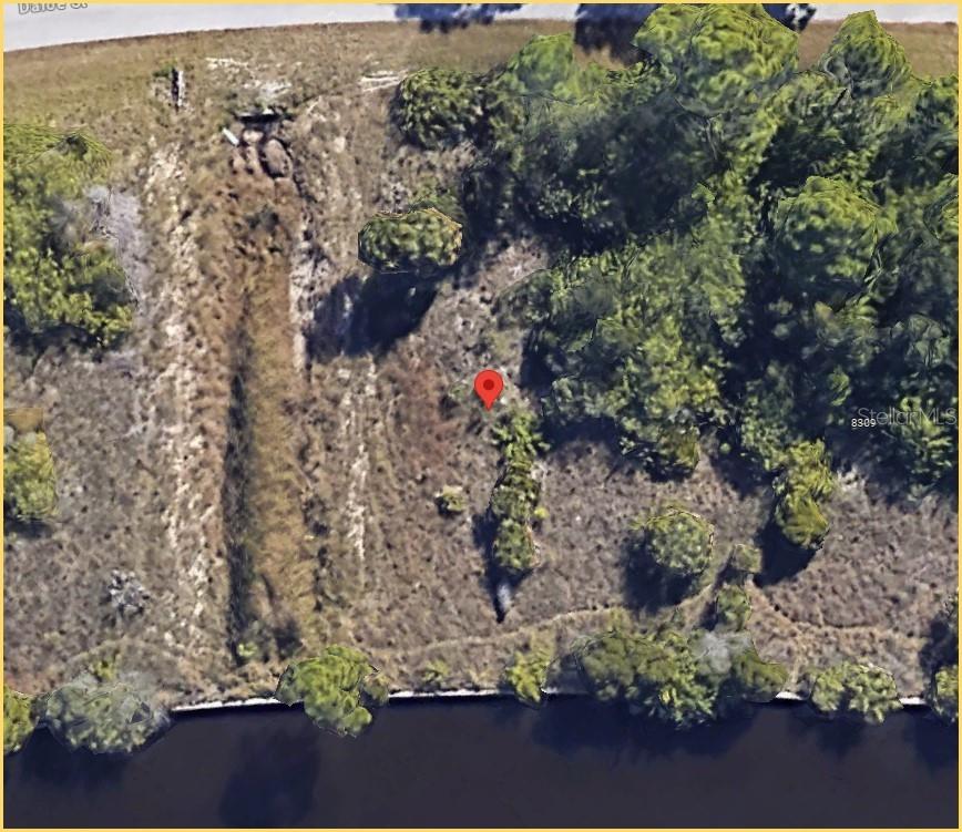 This aerial map shows a vacant, partially wooded lot bordering a body of water — 8301 DAFOE STREET, PORT CHARLOTTE, FL