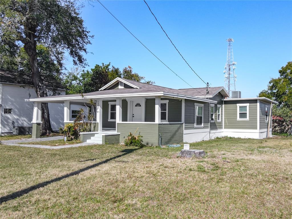 A single-story house with olive green siding, a covered front porch, and a carport — 1223 SYCAMORE STREET, LAKELAND, FL