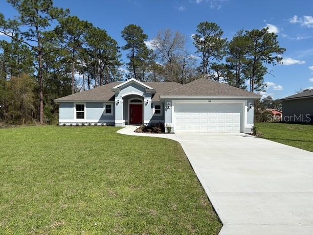 A light blue single-story house features a red front door and a two-car garage — 165 MARION OAKS PASS, OCALA, FL