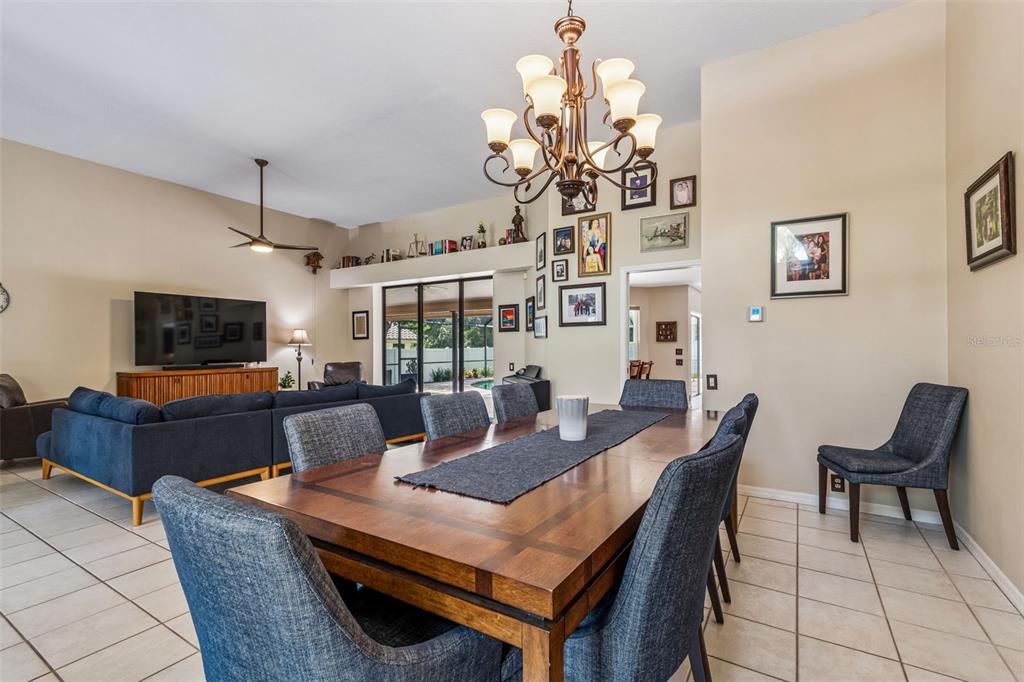 A dining area with a wooden table and chairs opens into a living room — 2937 HILLCREEK CIRCLE S, CLEARWATER, FL