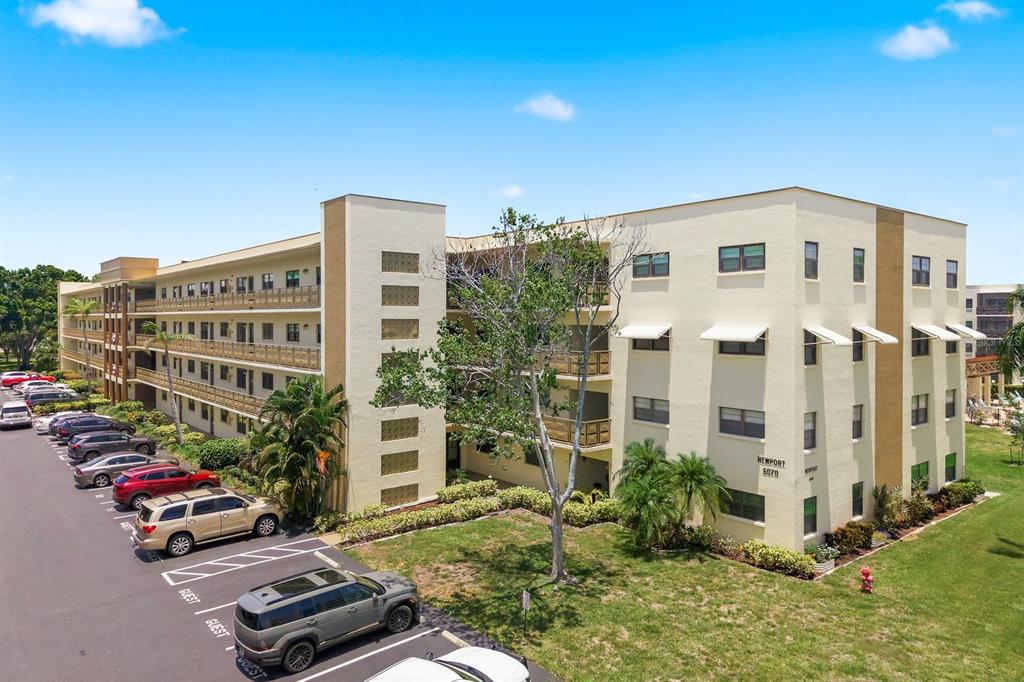 A multi-story apartment building with a parking lot in front and a grassy lawn — 6070 80TH STREET N UNIT 109, ST PETERSBURG, FL