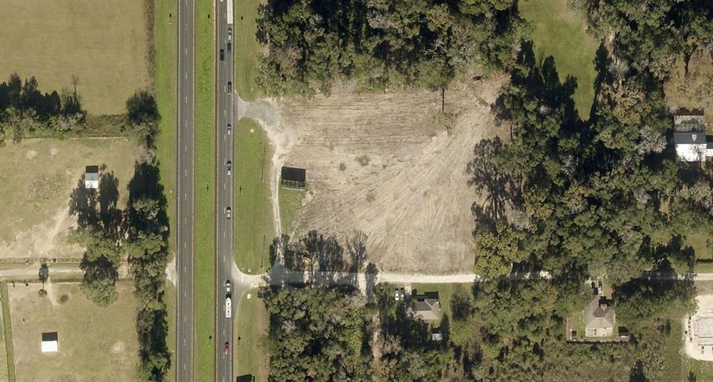 An aerial view shows a cleared, rectangular plot of land adjacent to a multi-lane highway — TBD N US HIGHWAY 441, CITRA, FL