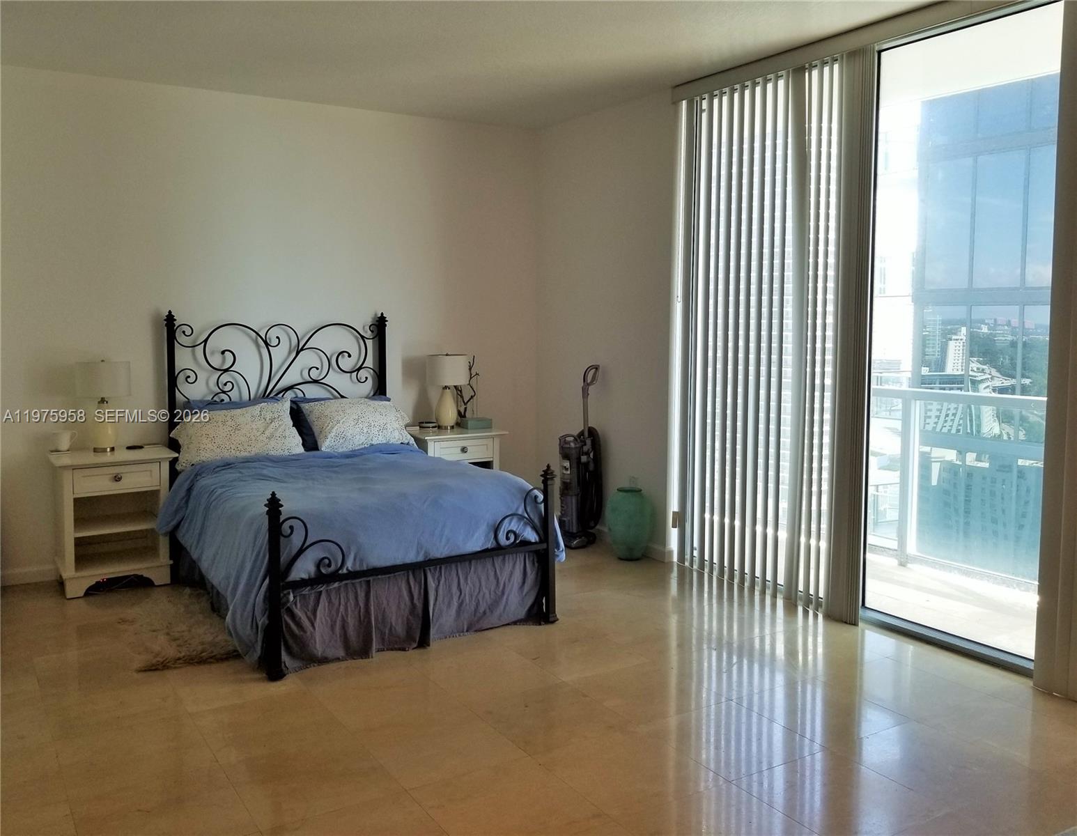 A bedroom with a metal bed frame, tile flooring, and floor-to-ceiling windows with vertical blinds — 1050 BRICKELL AV # 2622, Miami FL 33131, MIAMI, FL
