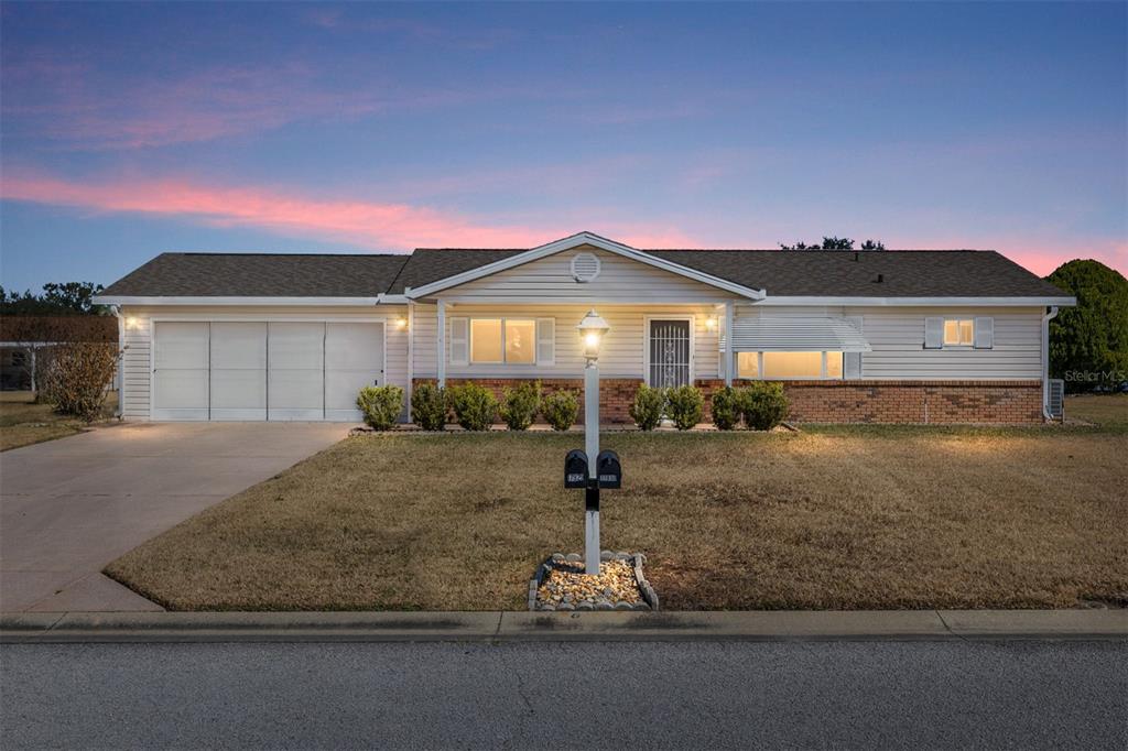 A single-story house with a white exterior, brick accents, and a two-car garage — 17929 SE 104TH TERRACE, SUMMERFIELD, FL