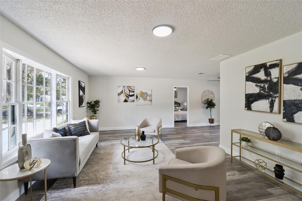 A living room features a grey sofa, two armchairs, a glass coffee table, and artwork — 2661 ELLEN AVENUE, KISSIMMEE, FL