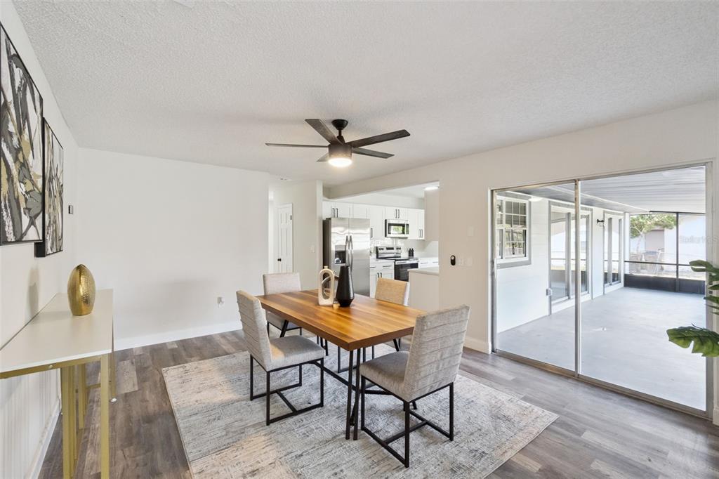 A dining room with wood-look flooring, a wooden table, and sliding doors to a patio — 2661 ELLEN AVENUE, KISSIMMEE, FL