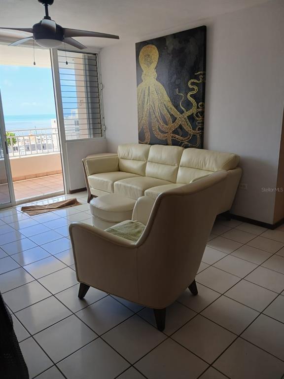 A living room features a cream-colored sofa and armchair, tile flooring, and an octopus wall art — Ave 400-A VISTA REAL UNIT 7-8, FAJARDO, PR