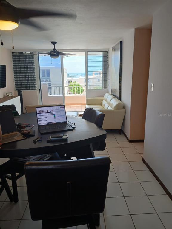 A dining area with a laptop on the table overlooks a balcony with ocean views — Ave 400-A VISTA REAL UNIT 7-8, FAJARDO, PR